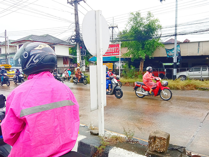 レインコートを着てバイクに乗る人々