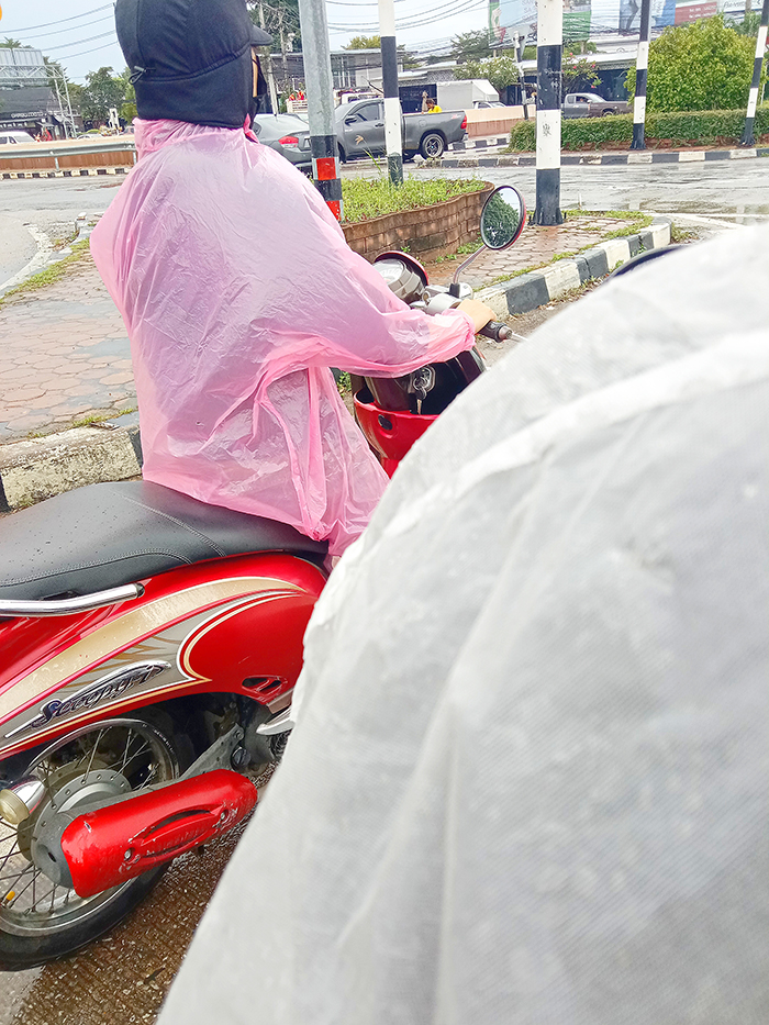 薄い素材のレインコートを着てバイクに乗っている人