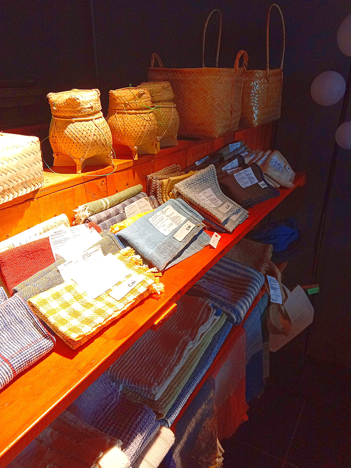 刺繍が入って可愛い布製品やラオスの籠小物が売られている様子