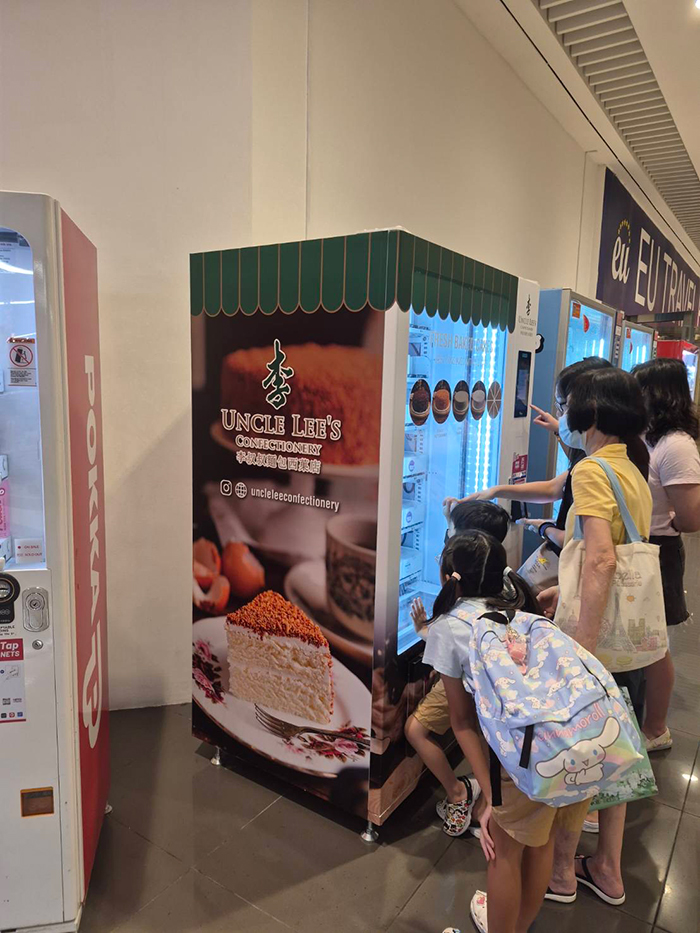 自動販売機でケーキを買う人々