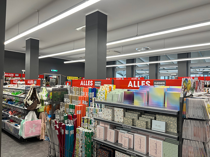 「ALLES(全部)」「KLEINSTE PREISE(最安価格)」 と書かれている赤いパネルが目立つ店内